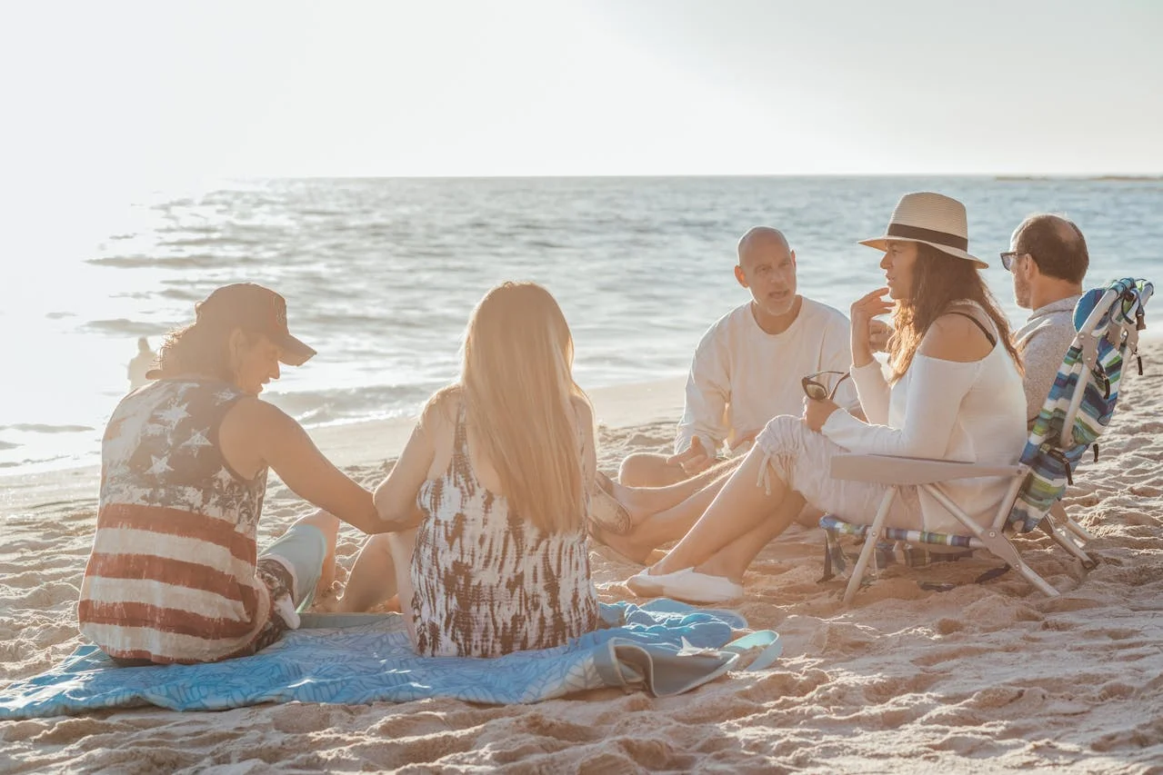 friends having picnic in front of sea excercisinf social wellness activity